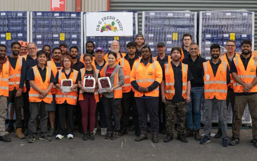 D&G Fresh Fruit staff group photo in front of produce pallets, 2025